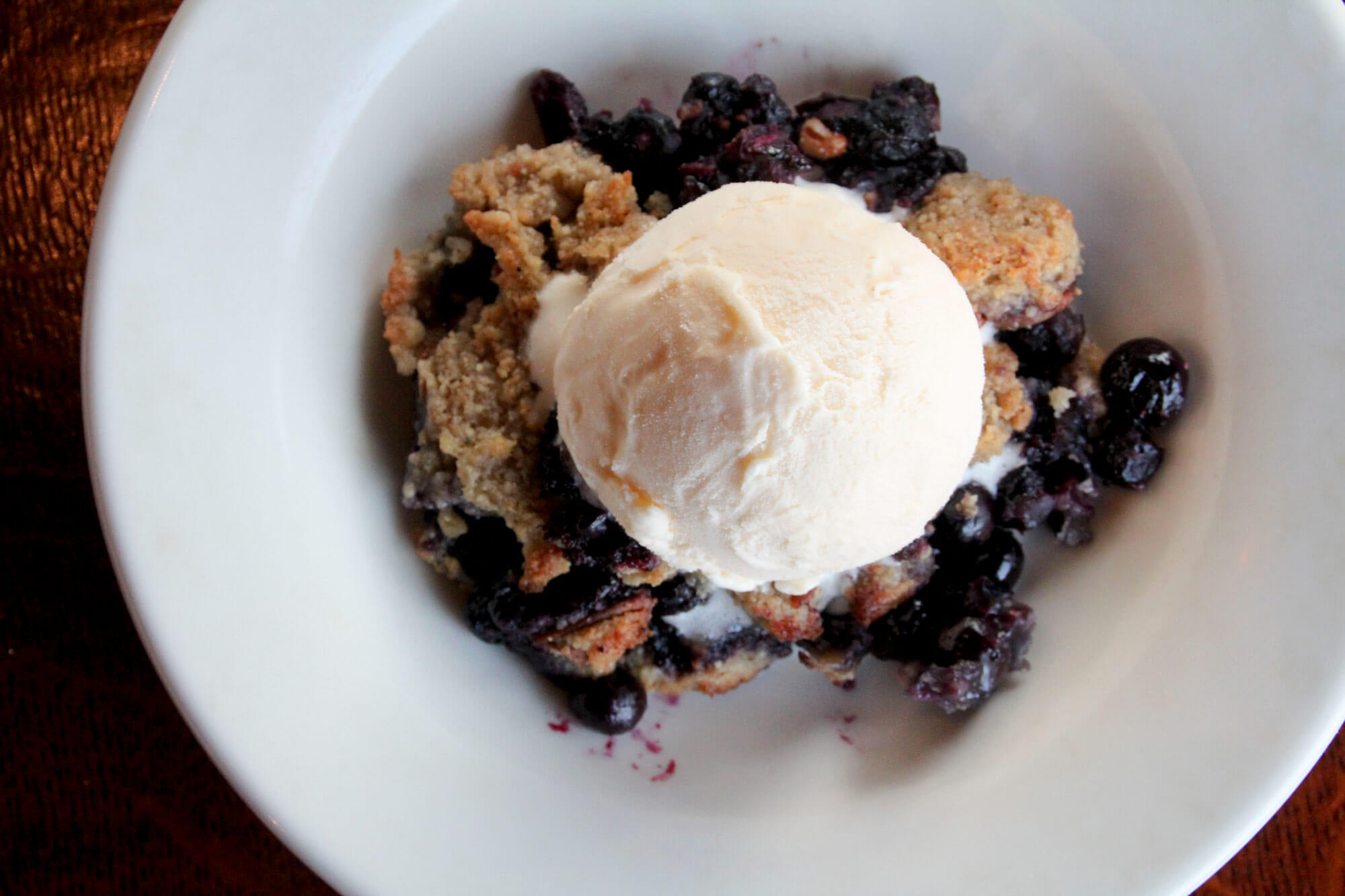 Ice cream over blueberry crumble